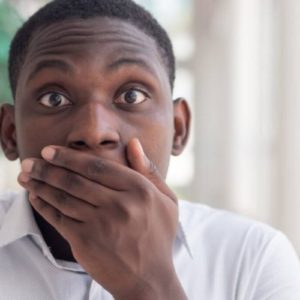 black man covering his mouth
