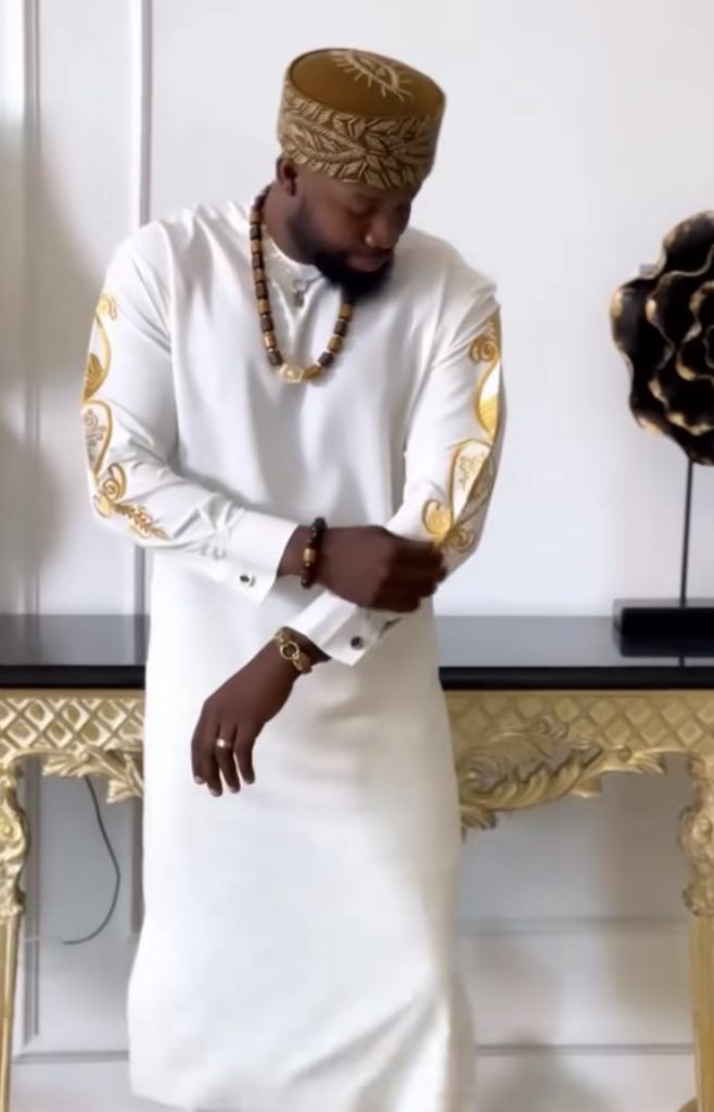 Man Wearing White Senator Design with Gold Embroidery on Sleeves